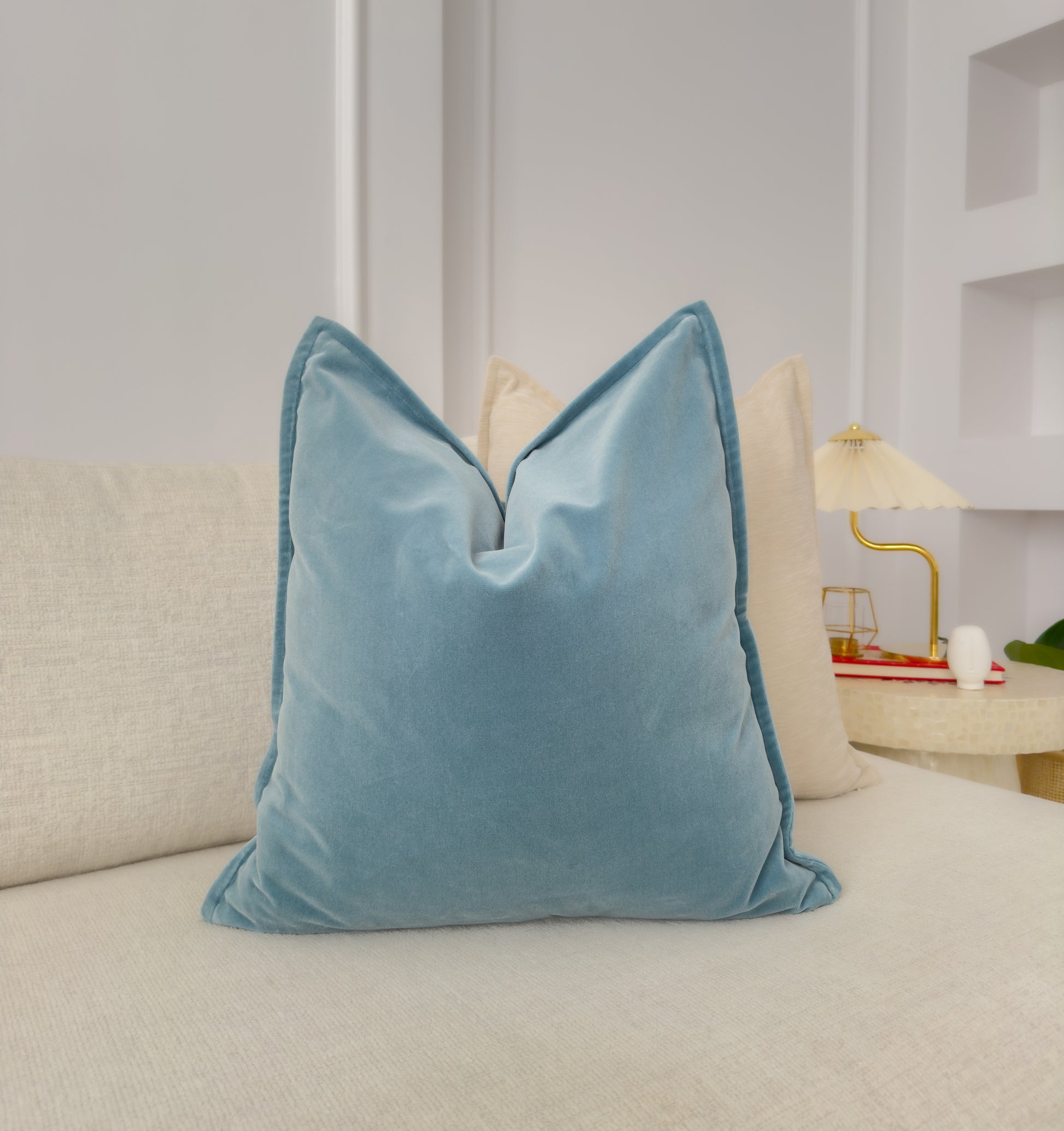 a blue pillow sitting on top of a white couch