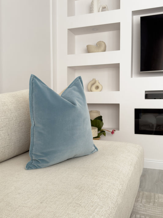 a white couch with a blue pillow on it