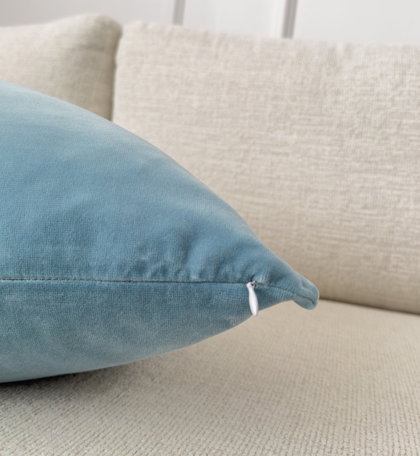 a close up of a blue pillow on a couch