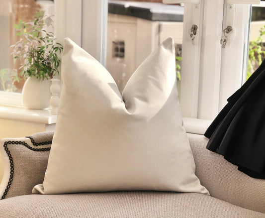 Cream Cushion on a sofa with a blurred indoor background