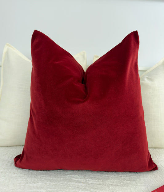 Red pillow on a white surface with a neutral background