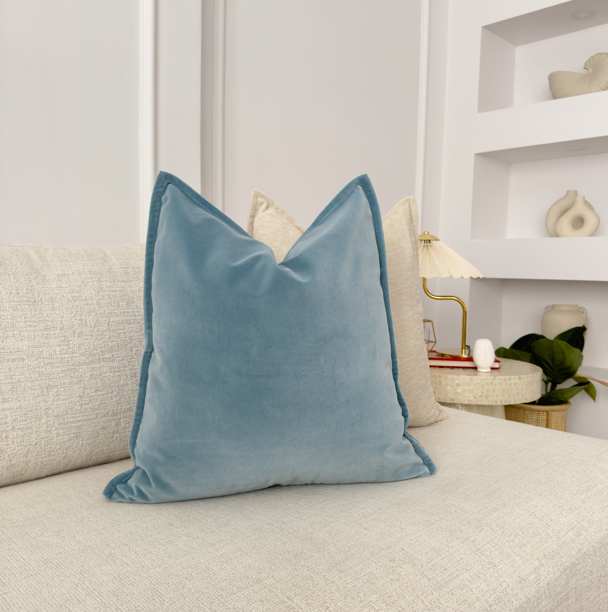 a blue pillow sitting on top of a white couch