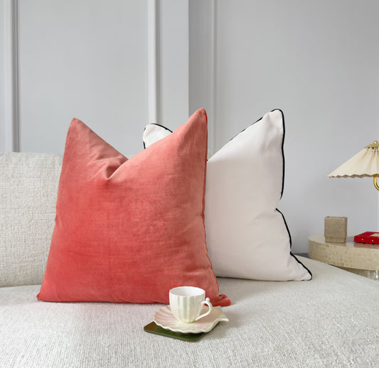 a white couch with two pillows and a cup of coffee