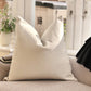 Cream Cushion on a sofa with a blurred indoor background