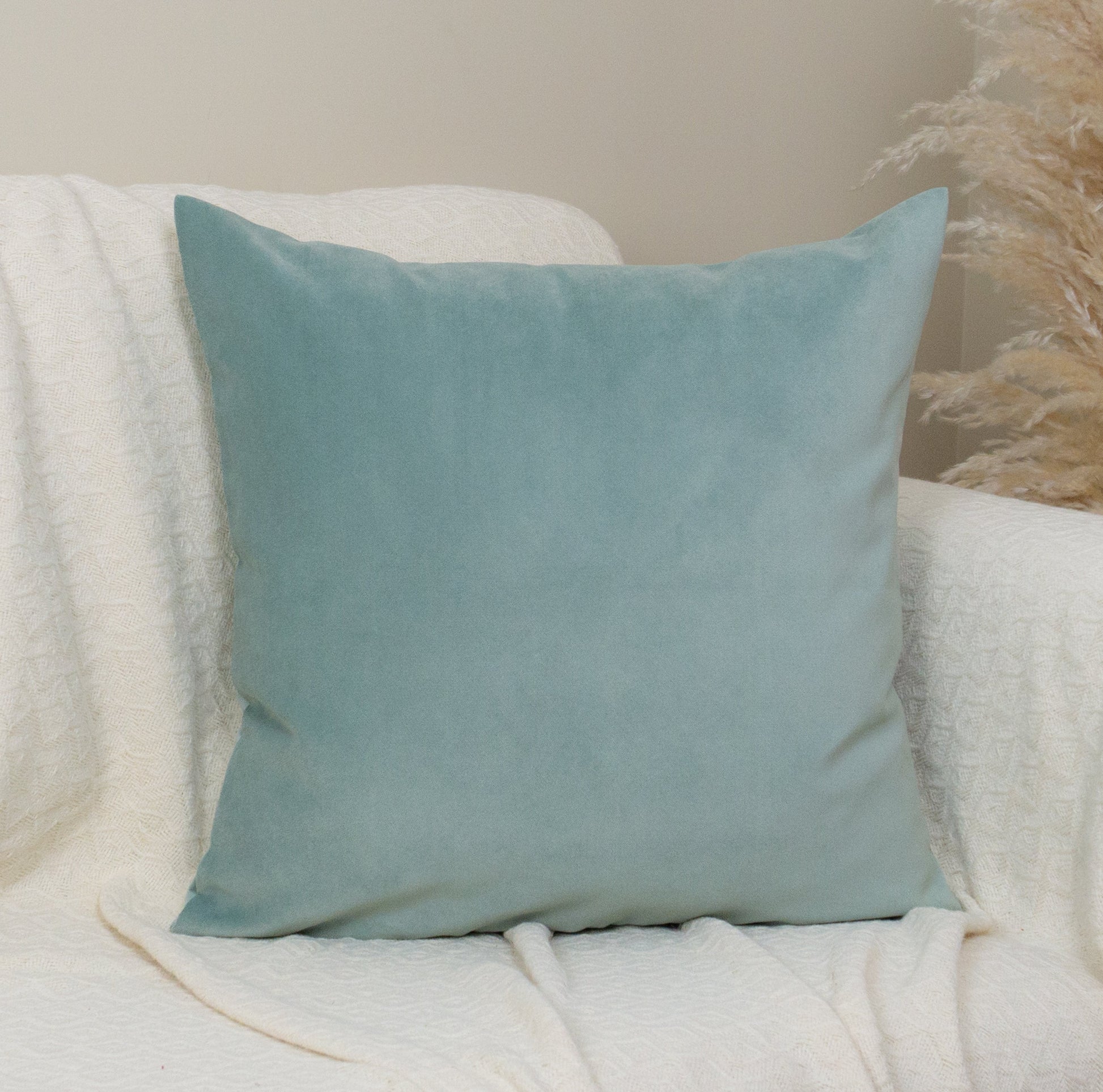 Light blue pillow on a white armchair with a neutral background