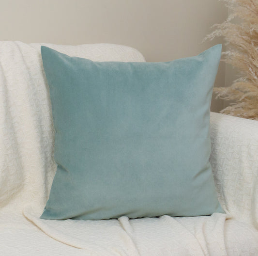 Light blue pillow on a white armchair with a neutral background