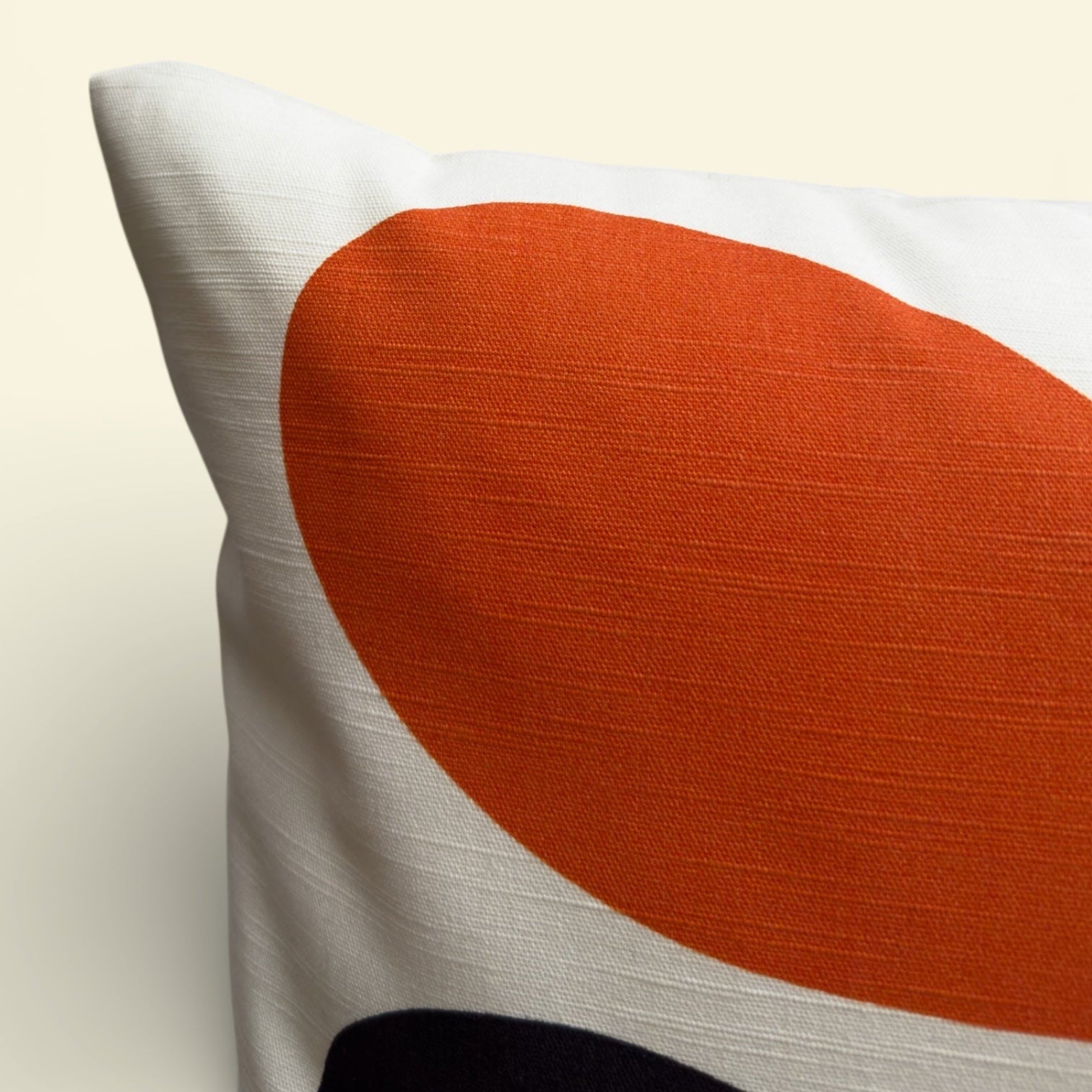 Decorative pillow with a large orange circle on a beige background