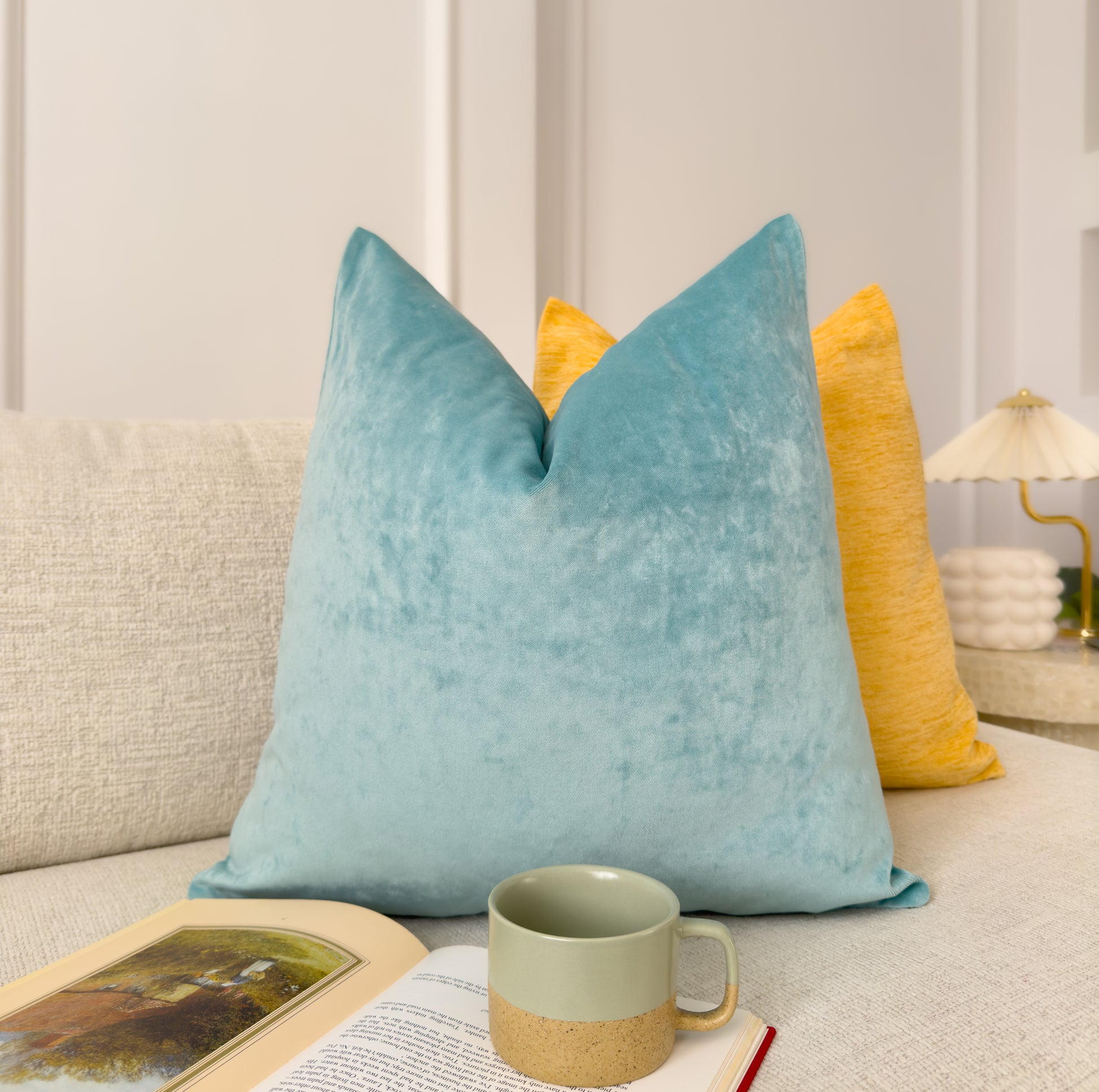 a coffee cup and a book on a couch
